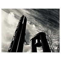 Black and white photo of Grass Valley sign and bell with clouds in the background. Photo taken by Austin Metzger